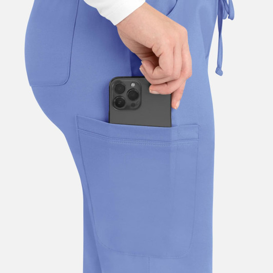 A close-up of light blue cargo pants with a smartphone being placed in the side pocket.