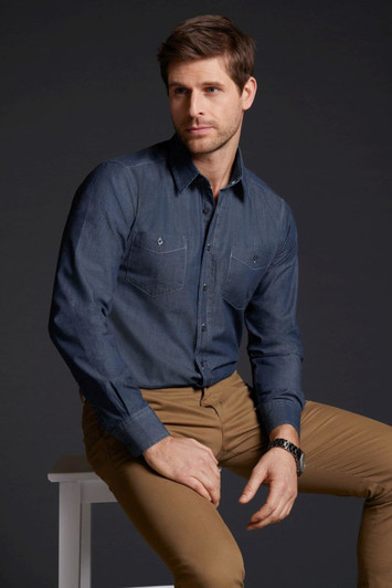 A men's button-up denim shirt in dark blue, featuring two chest pockets, worn with tan trousers.