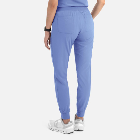 A pair of women's joggers in light blue with elastic cuffs and back pockets, featuring a logo.
