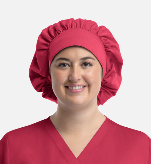A unisex bouffant scrub cap in bright pink, featuring a gathered design and a wide band.