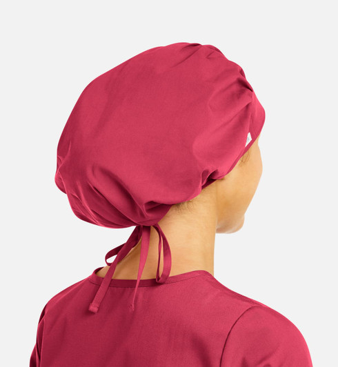 A unisex bouffant scrub cap in a deep pink colour, featuring a gathered design and adjustable ties at the back.
