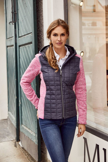 A ladies' knitted hybrid jacket featuring a grey quilted front and pink sleeves, paired with blue jeans.