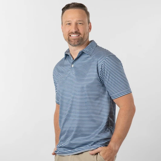 A man wearing a blue and white striped golf polo, posed casually against a plain background. The polo has a subtle logo.