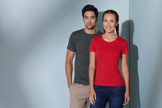 A grey men's T-shirt and a red women's T-shirt on models standing against a light blue background. Both shirts have logos.