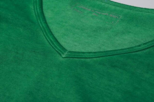 A close-up view of a green men's T-shirt featuring a V-neck design and visible stitching details.