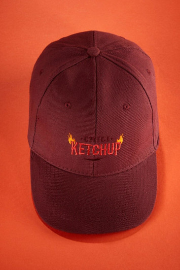 A maroon six-panel cap made of heavy cotton with a logo on the front.