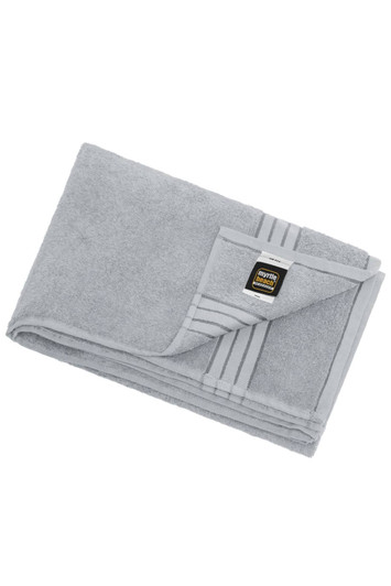 A grey bath sheet featuring a folded design and a logo on the corner. Soft and absorbent fabric.