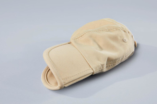 A beige 6 Panel Pack-a-Cap laying flat, featuring a curved brim and a branded logo.