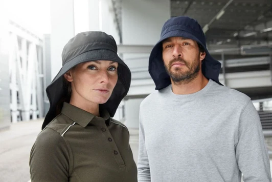 A black and navy cap with a wide neck guard, worn by a man and woman in casual clothing.