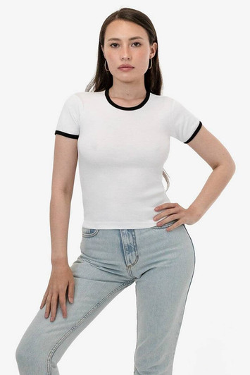 A fitted white baby rib tee with black trim, worn by a model posing in light blue jeans.
