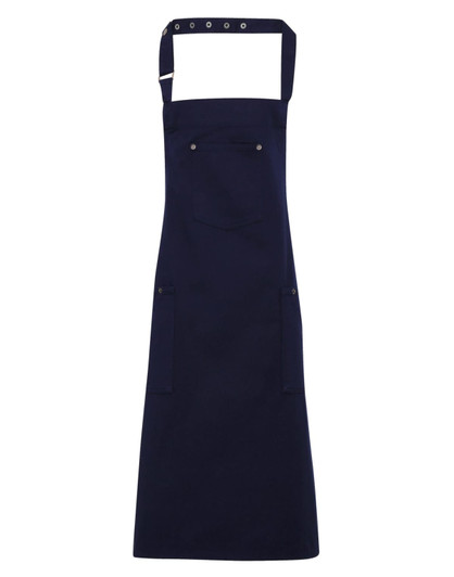 A navy blue Chino Cotton Bib Apron with adjustable straps and multiple pockets, featuring a logo.