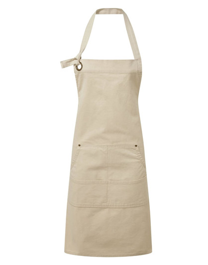 A beige heavy cotton canvas apron with adjustable neck strap and front pockets. It features a logo on the fabric.