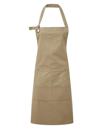 A heavy cotton canvas apron in a khaki colour, featuring multiple pockets and an adjustable strap.