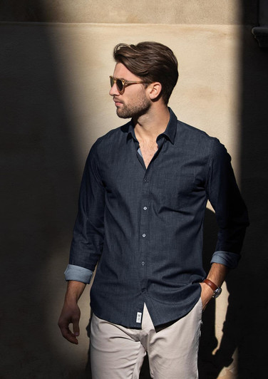 A modern fit men's button-up shirt in navy, featuring a collar and rolled sleeves, displayed on a model.