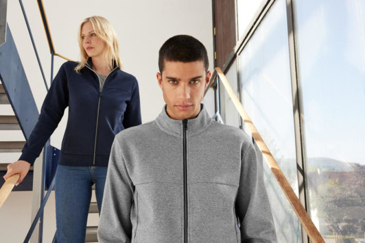 A grey and navy ladies jacket featured on two models, one standing on stairs and the other in front.