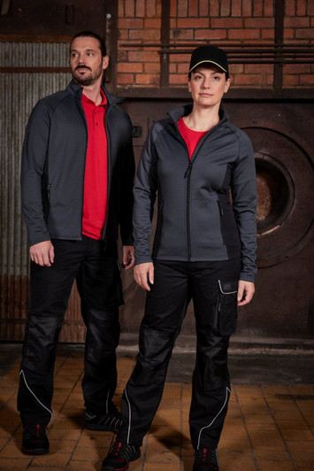 A grey men's stretch fleece jacket worn by a man and a black jacket worn by a woman, both with red shirts underneath.