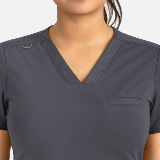 A women's grey banded v-neck top featuring a pocket and a logo.