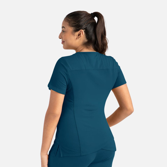 A woman wearing a teal curved V-neck top, featuring short sleeves and a fitted design, viewed from the back.