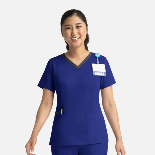 A woman's blue double V-neck top with contrasting neckline, featuring a pocket and a name badge holder.