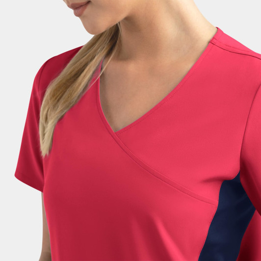 A women's mock wrap top in bright pink with contrast navy panels, featuring a deep V-neck design.