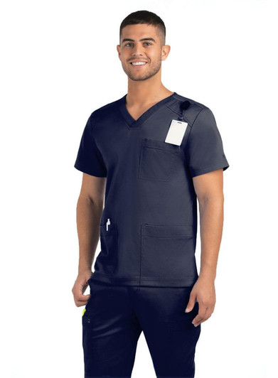 A man wearing a navy V-neck top with three pockets, featuring a logo and a tag.