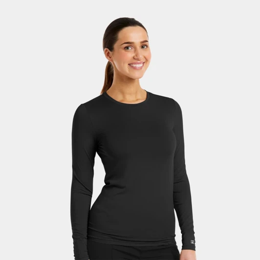A black long-sleeve underscrub tee is displayed on a smiling model. The tee has a fitted design and a logo.