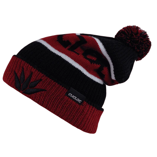 A beanie in black and red with a pom-pom on top and a logo patch.