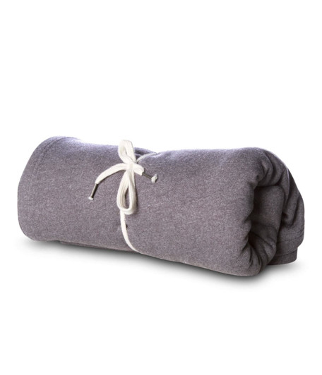 A rolled grey blanket tied with cream ties, featuring a simple, soft, and textured fabric.