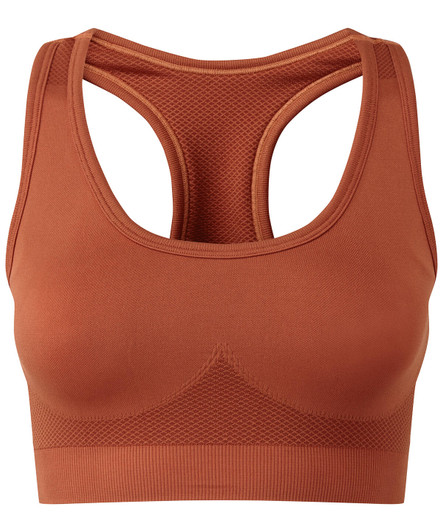 A seamless sports bra in a rich terracotta colour, featuring a mesh back design and a logo.