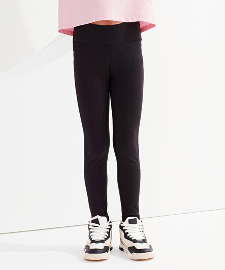 Black recycled performance leggings for kids, featuring a stretchy waistband and a fitted design, paired with sporty shoes.