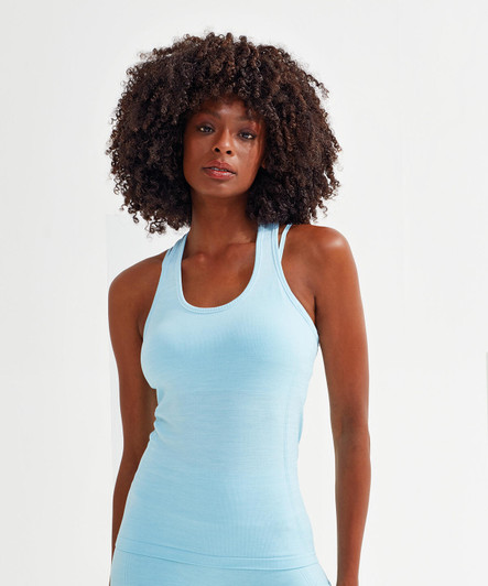 A seamless light blue sport vest featuring a fitted design and logo. The model has curly hair.