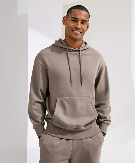 A unisex recycled hoodie in a neutral brown shade features a front pocket and an adjustable drawstring hood.