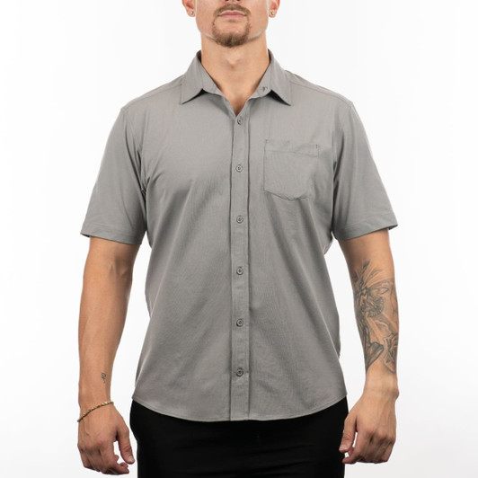 A short sleeve shirt in grey, featuring a button-up front and a chest pocket, displayed on a model.