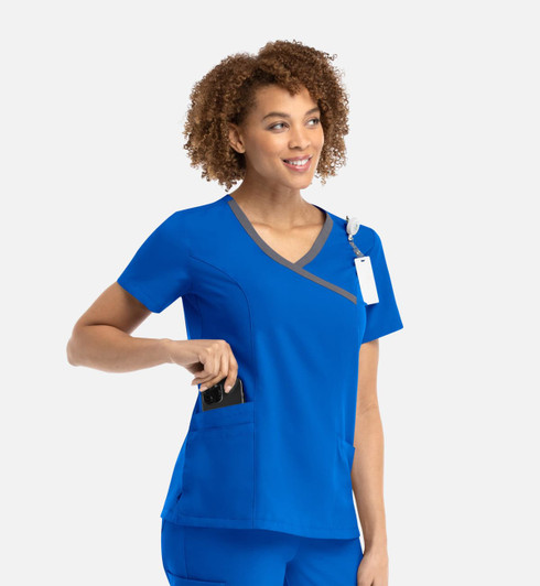 A women's mock wrap top in vibrant blue with contrast grey trim and pockets, featuring a logo.