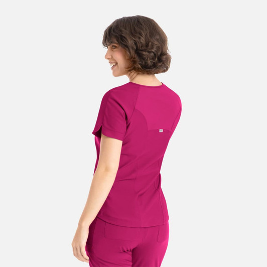 A vibrant pink Y-neck top with short sleeves and a small logo on the back, featuring a snug fit.