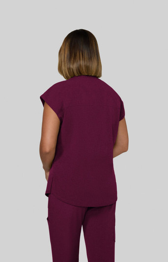 A woman in a maroon top, viewed from the back, wearing matching pants. The outfit has a casual design.