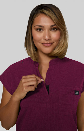 A short-sleeve women's top in a rich plum colour, featuring a zip neck and a small logo on the chest.