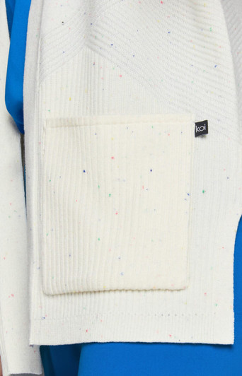 A white Kori sweater with a textured pattern and a pocket, featuring multicoloured specks on the fabric.