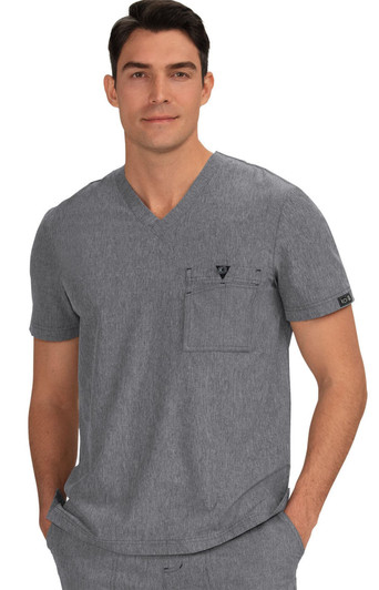 A grey V-neck scrub top featuring a chest pocket and a logo. The model is casually posing with hands in pockets.