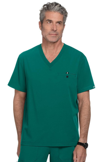 A teal V-neck scrubs top featuring a chest pocket and a logo on the sleeve. The model has grey hair.