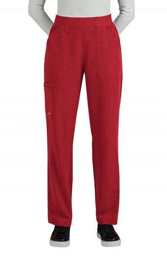 A pair of red boot cut pants features multiple pockets and a comfortable waistband. The model stands with hands in pockets.