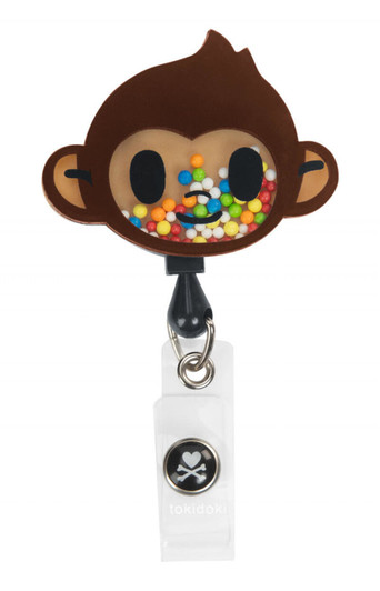 A whimsical brown monkey badge featuring colourful sprinkles, attached to a clear clip with a logo.
