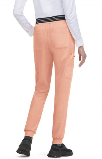 A pair of peach joggers with a black waistband and pockets, worn by a person facing away.