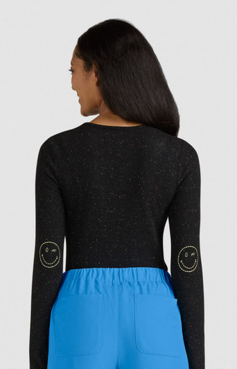 A black long-sleeve top featuring smiley face designs on the elbows, paired with blue bottoms.