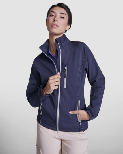 A women's softshell jacket in navy blue, featuring a high collar and zippered pockets, with branding visible.