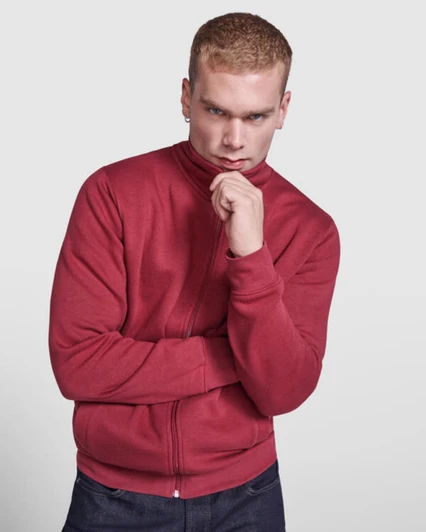 A red sweatshirt worn by a model with a high collar and zip closure. The model has a thoughtful pose.