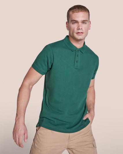 A green polo shirt featuring a collar and button placket, worn by a model. The shirt has a logo on it.