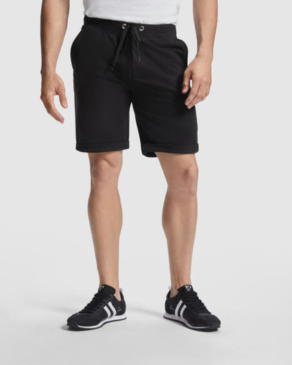 Black sports shorts with an elastic waistband and drawstring, featuring pockets and paired with black sneakers.
