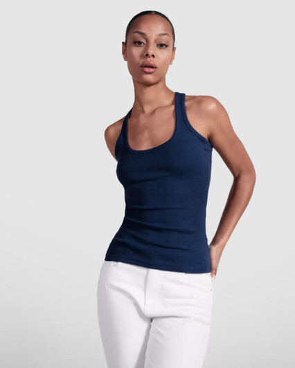 A navy tank top with a fitted design displayed on a model, paired with white trousers. The top features a logo.
