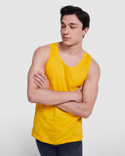 A young man in a bright yellow tank top with a casual pose and crossing his arms. The top has a logo.